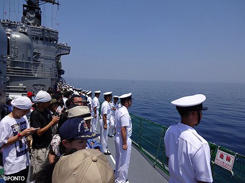 隊員が甲板ですれ違う船に向かって一列に並んだ写真